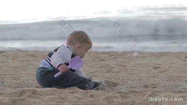 夏天，小男孩在海滩上玩铲子和沙子